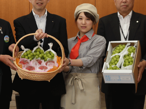 福島県知事の福島産ブドウとモモを贈る綺麗な女性（ベジフルコーディネーター）
